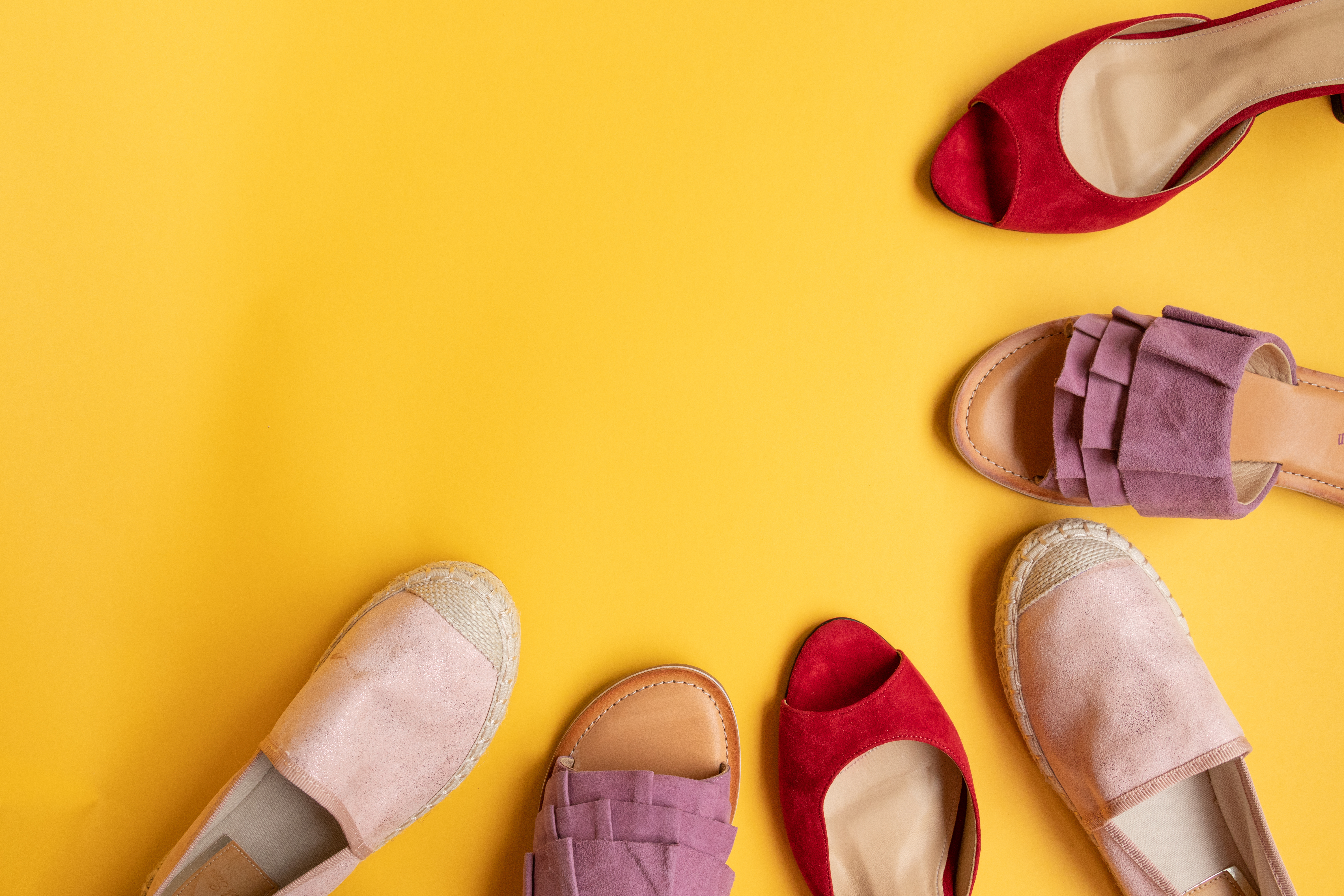 A variety of shoes on a yellow background.